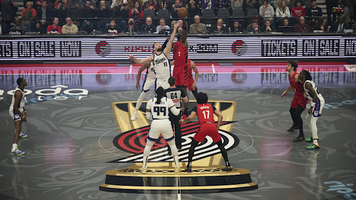 Nov 29, 2024; Portland, Oregon, USA; Sacramento Kings forward Domantas Sabonis (11) and Portland Trail Blazers center Deandre Ayton (2) leap for control of the ball during a game at Moda Center. Mandatory Credit: Troy Wayrynen-Imagn Images