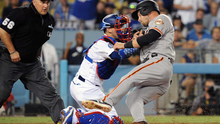 San Francisco Giants left fielder Austin Slater (53) is out at home against Los Angeles Dodgers catcher Yasmani Grandal (9) on a scoring attempt in the ninth inning at Dodger Stadium on Aug. 14, 2018.