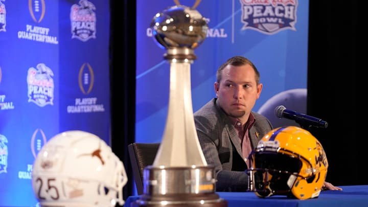 Arizona State head coach Kenny Dillingham listens to a response by Texas head coach Steve Sarkisian during a joint news conference before facing off in the Chick-fil-A Peach Bowl.