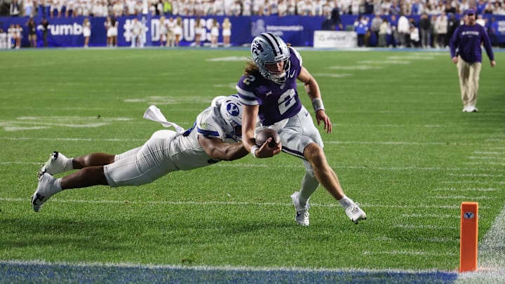 Sep 21, 2024; Provo, Utah, USA; Kansas State Wildcats quarterback Avery Johnson (2) is pursued by Brigham Young Cougars defensive end Logan Lutui (59) during the third quarter at LaVell Edwards Stadium. Mandatory Credit: Rob Gray-Imagn Images Sep 21, 2024; Provo, Utah, USA; Kansas State Wildcats quarterback Avery Johnson (2) is pursued by Brigham Young Cougars defensive end Logan Lutui (59) during the third quarter at LaVell Edwards Stadium. Mandatory Credit: Rob Gray-Imagn Images
