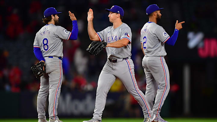 Sep 27, 2024; Anaheim, California, USA; Texas Rangers second baseman Marcus Semien (2) shortstop Josh Smith (8) and center fielder Wyatt Langford (36) celebrate the victory against the Los Angeles Angels at Angel Stadium.