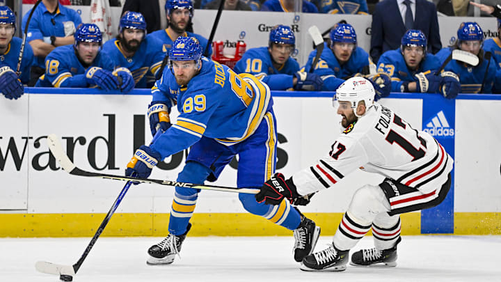 Dec 23, 2023; St. Louis, Missouri, USA;  St. Louis Blues left wing Pavel Buchnevich (89) and Chicago Blackhawks left wing Nick Foligno (17) battle for the puck during the first period at Enterprise Center. Mandatory Credit: Jeff Curry-Imagn Images