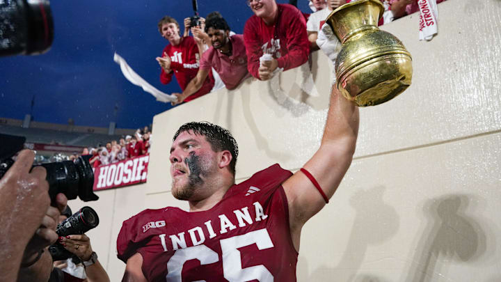 Oct 18, 2025; Bloomington, Indiana, USA; Indiana Hoosiers offensive lineman Carter Smith (65) celebrates with the Old Brass Spittoon after the game against the Michigan State Spartans at Memorial Stadium. Mandatory Credit: Robert Goddin-Imagn Images