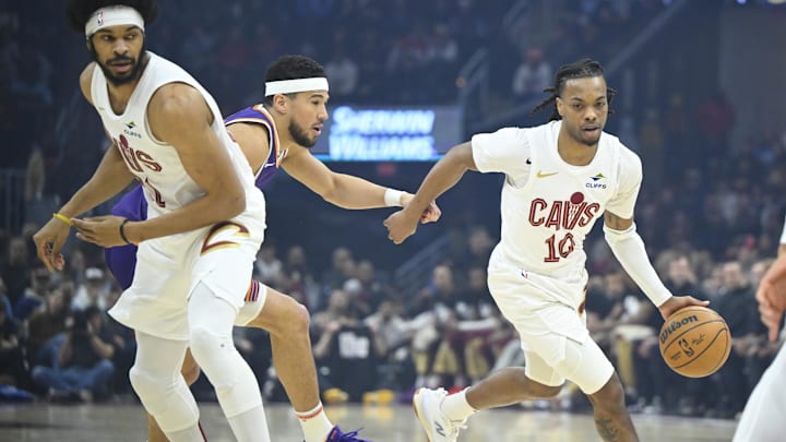 Jan 20, 2025; Cleveland, Ohio, USA; Cleveland Cavaliers guard Darius Garland (10) dribbles around center Jarrett Allen (31) and Phoenix Suns guard Devin Booker (1) in the first quarter at Rocket Mortgage FieldHouse. Mandatory Credit: David Richard-Imagn Images