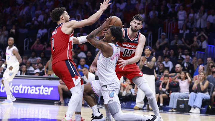 Apr 13, 2025; Miami, Florida, USA;  Washington Wizards guard Colby Jones (1) and  forward Tristan Vukcevic (00) defend Miami Heat guard Josh Christopher (8) during the second half at Kaseya Center. Mandatory Credit: Rhona Wise-Imagn Images