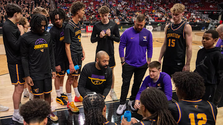 Johnston goes over a play between quarters during a semifinal game of the Iowa high school boys state basketball tournament at the Casey's Center in Des Moines, March 12, 2026.