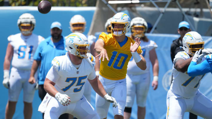 May 29, 2024; Costa Mesa, CA, USA; Los Angeles Chargers quarterback Justin Herbert (10) throws the ball as center Bradley Bozeman (75) and guard Zion Johnson (77) defend during organized team activities at Hoag Performance Center. Mandatory Credit: Kirby Lee-USA TODAY Sports