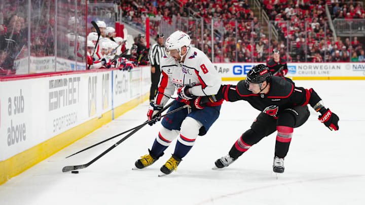 May 10, 2025; Raleigh, North Carolina, USA; Washington Capitals left wing Alex Ovechkin (8) skates with the puck outside of Carolina Hurricanes defenseman Dmitry Orlov (7) during the second period in game three of the second round of the 2025 Stanley Cup Playoffs at Lenovo Center. Mandatory Credit: James Guillory-Imagn Images