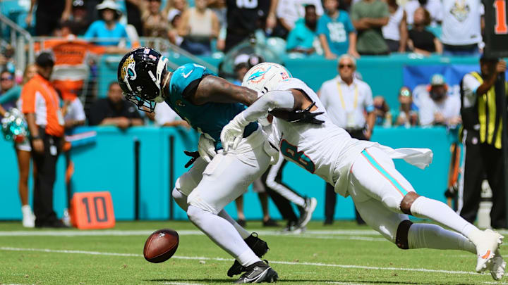 Sep 8, 2024; Miami Gardens, Florida, USA; Jacksonville Jaguars running back Travis Etienne Jr. (1) fumbles the football after a tackle from Miami Dolphins safety Jevon Holland (8) during the third quarter at Hard Rock Stadium. Mandatory Credit: Sam Navarro-Imagn Images Sep 8, 2024; Miami Gardens, Florida, USA; Jacksonville Jaguars running back Travis Etienne Jr. (1) fumbles the football after a tackle from Miami Dolphins safety Jevon Holland (8) during the third quarter at Hard Rock Stadium. Mandatory Credit: Sam Navarro-Imagn Images
