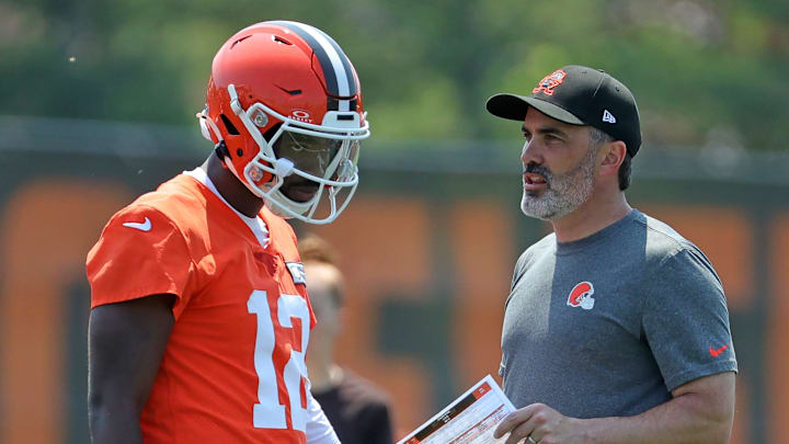 Cleveland Browns quarterback Shedeur Sanders speaks with coach Kevin Stefanski during practice at minicamp June 11, 2025, in Berea, Ohio.