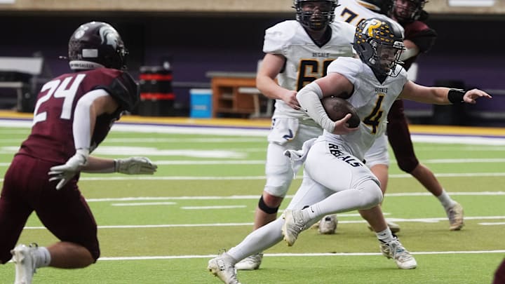 Regina's quarterback Kyle Tracy (4) runs for a touchdown around Grundy Center's running back/line backer Hayden Geerdes (24) during the second quarter in the 1A High School state semi-final on Nov. 14, 2025, at UNI-Dome in Cedar Falls, Iowa.