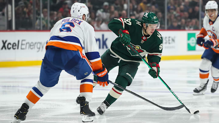 Nov 7, 2021; Saint Paul, Minnesota, USA; Minnesota Wild left wing Kirill Kaprizov (97) skates with the puck while New York Islanders defenseman Ryan Pulock (6) defends in the second period at Xcel Energy Center. Mandatory Credit: David Berding-Imagn Images