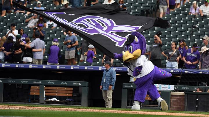 Colorado Rockies mascot Dinger waives a flag after a win.