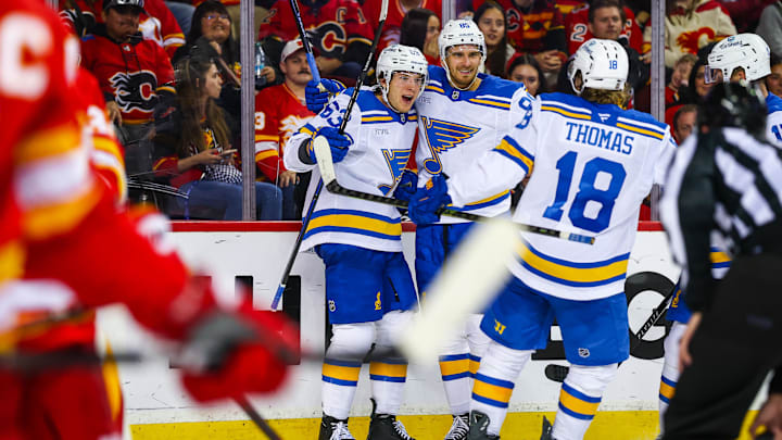 Oct 11, 2025; Calgary, Alberta, CAN; St. Louis Blues left wing Jake Neighbours (63) celebrates his goal with teammates against the Calgary Flames during the third period at Scotiabank Saddledome. Mandatory Credit: Sergei Belski-Imagn Images