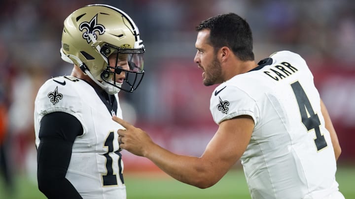 Aug 10, 2024; Glendale, Arizona, USA; New Orleans Saints quarterback Derek Carr (4) talks with Spencer Rattler (18) against the Arizona Cardinals during a preseason NFL game at State Farm Stadium. Mandatory Credit: Mark J. Rebilas-Imagn Images Aug 10, 2024; Glendale, Arizona, USA; New Orleans Saints quarterback Derek Carr (4) talks with Spencer Rattler (18) against the Arizona Cardinals during a preseason NFL game at State Farm Stadium. Mandatory Credit: Mark J. Rebilas-Imagn Images