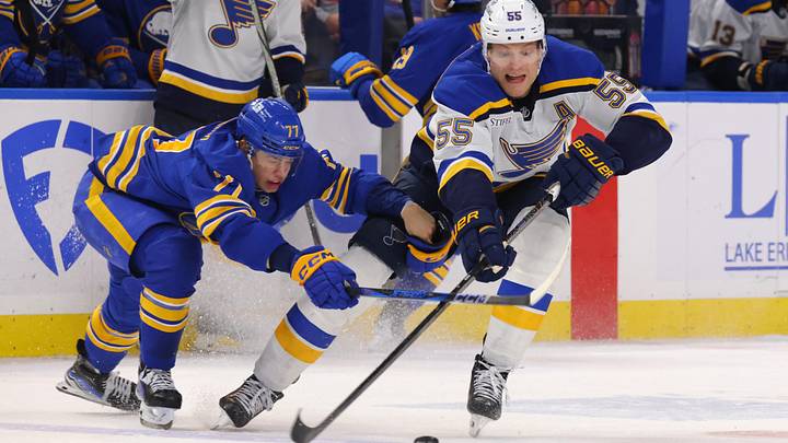 Nov 14, 2024; Buffalo, New York, USA;  St. Louis Blues defenseman Colton Parayko (55) makes a pass as Buffalo Sabres right wing JJ Peterka (77) defends during the third period at KeyBank Center. Mandatory Credit: Timothy T. Ludwig-Imagn Images