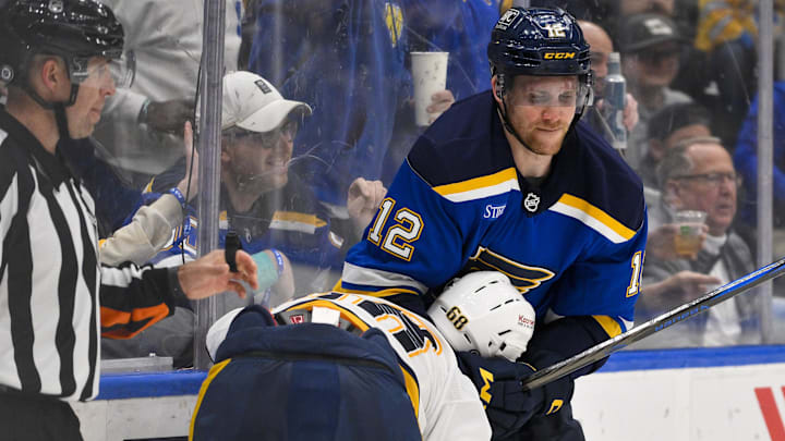 Mar 23, 2025; St. Louis, Missouri, USA;  St. Louis Blues center Radek Faksa (12) grabs Nashville Predators left wing Zachary L'Heureux (68) during the third period at Enterprise Center. Mandatory Credit: Jeff Curry-Imagn Images