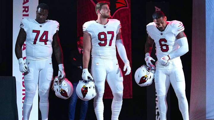Cardinals players D.J. Humphries (74), Cameron Thomas (97), and James Conner (6) pose for pictures