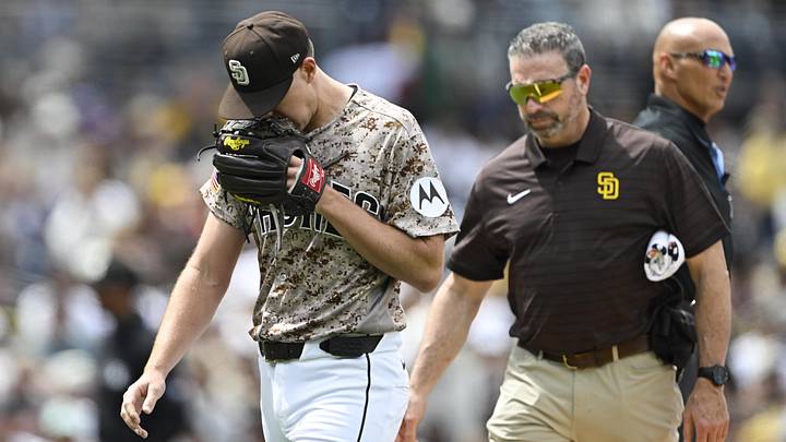 Apr 12, 2026; San Diego, California, USA; San Diego Padres starting pitcher Nick Pivetta (27), left, leaves the field with a trainer during the fourth inning against the Colorado Rockies at Petco Park. Mandatory Credit: Denis Poroy-Imagn Images