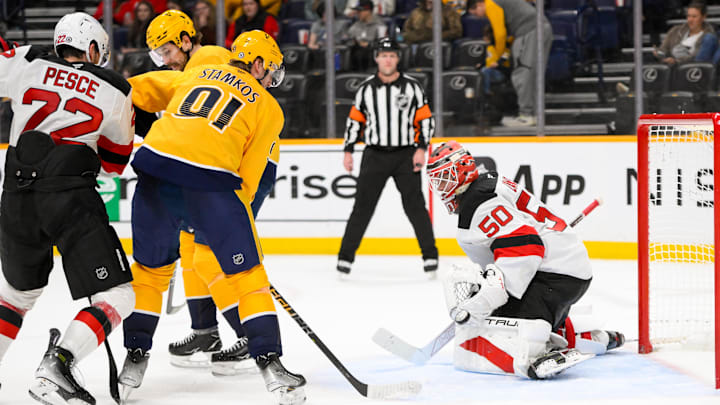 New Jersey Devils goaltender Nico Daws (50) blocks the shot of Nashville Predators center Ryan O'Reilly (90) during the third half at Bridgestone Arena. Mandatory Credit: Steve Roberts-Imagn Images