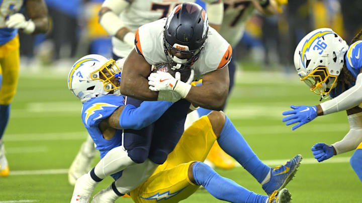 Dec 19, 2024; Inglewood, California, USA; Denver Broncos running back Audric Estime (23) is stopped by Los Angeles Chargers safety Derwin James Jr. (3) in the first half at SoFi Stadium. 