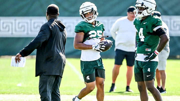 Michigan State's Jace Clarizio, center, listens to coaches after a drill during football practice on Monday, Aug. 11, 2025, in East Lansing.