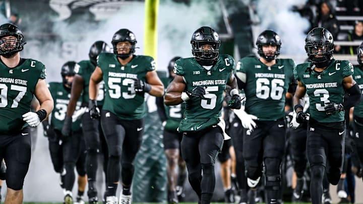 Michigan State's Nathan Carter, center, and the team take the field before the football game against Purdue on Friday, Nov. 22, 2024, at Spartan Stadium in East Lansing.