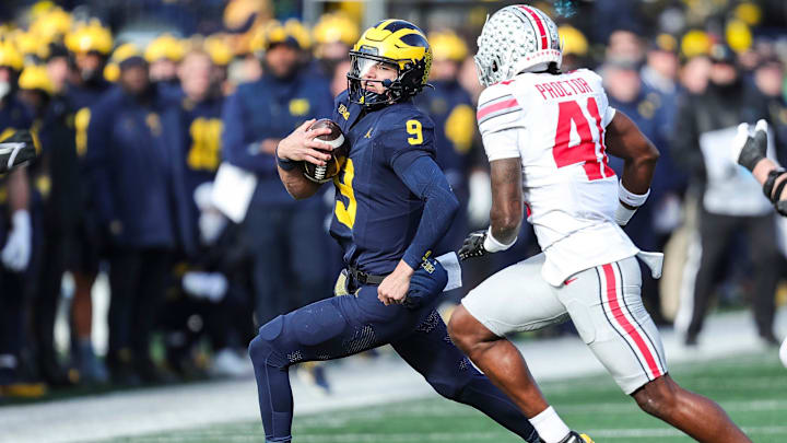 Michigan quarterback J.J. McCarthy runs against Ohio State safety Josh Proctor during the first half at Michigan Stadium in Ann Arbor on Saturday, Nov. 25, 2023.