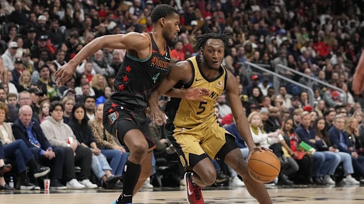 Apr 7, 2024; Toronto, Ontario, CAN;  Toronto Raptors guard Immanuel Quickley (5) drives to the net against Washington Wizards guard Jared Butler (4) during the second half at Scotiabank Arena. Mandatory Credit: John E. Sokolowski-Imagn Images