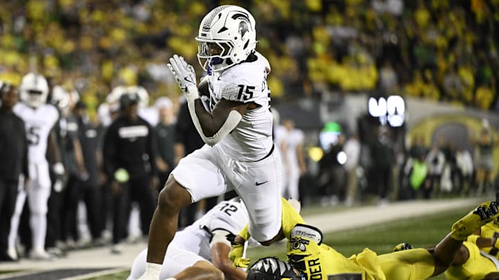 Oct 4, 2024; Eugene, Oregon, USA; Michigan State Spartans running back Kay'Ron Lynch-Adams (15) breaks away from Oregon Ducks defensive back Dakoda Fields (11) during the second half at Autzen Stadium. Mandatory Credit: Troy Wayrynen-Imagn Images