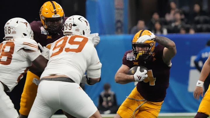 Arizona State running back Cam Skattebo (4) cuts past Texas defensive lineman Jermayne Lole (99) during the first quarter of the Chick-fil-A Peach Bowl on Jan 1, 2025, in Atlanta, Ga. Arizona State running back Cam Skattebo (4) cuts past Texas defensive lineman Jermayne Lole (99) during the first quarter of the Chick-fil-A Peach Bowl on Jan 1, 2025, in Atlanta, Ga.