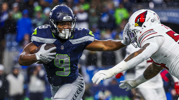 Nov 24, 2024; Seattle, Washington, USA; Seattle Seahawks running back Kenneth Walker III (9) stiff-arms away from a tackle attempt by Arizona Cardinals linebacker Xavier Thomas (54) after catching a pass during the fourth quarter at Lumen Field. Mandatory Credit: Joe Nicholson-Imagn Images