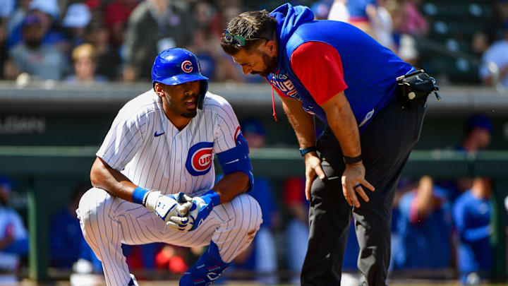 Mar 21, 2022; Mesa, Arizona, USA; Chicago Cubs right field Brennen Davis talks to a trainer after being hit by a pitch in the second inning against the Cincinnati Reds during spring training at Sloan Park. Mandatory Credit: Matt Kartozian-Imagn Images