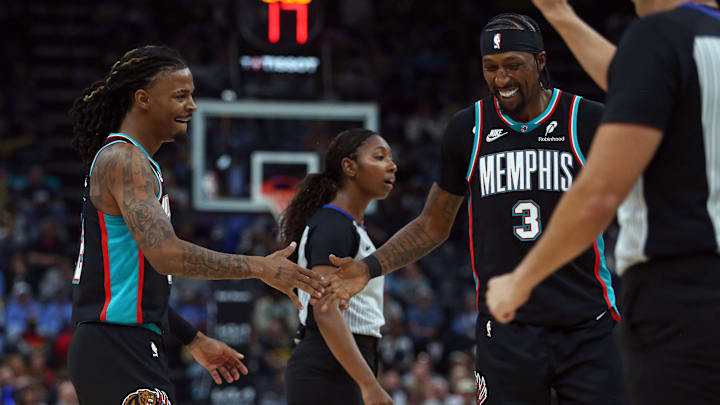 Oct 22, 2025; Memphis, Tennessee, USA; Memphis Grizzlies guard Ja Morant (12) reacts with forward Kentavious Caldwell-Pope (3) during the second quarter against the New Orleans Pelicans at FedExForum. Mandatory Credit: Petre Thomas-Imagn Images