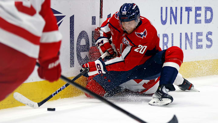 Mar 18, 2025; Washington, District of Columbia, USA; Washington Capitals center Lars Eller (20) checks Detroit Red Wings defenseman Erik Gustafsson (56) while going for the puck during the third period at Capital One Arena. Mandatory Credit: Peter Casey-Imagn Images