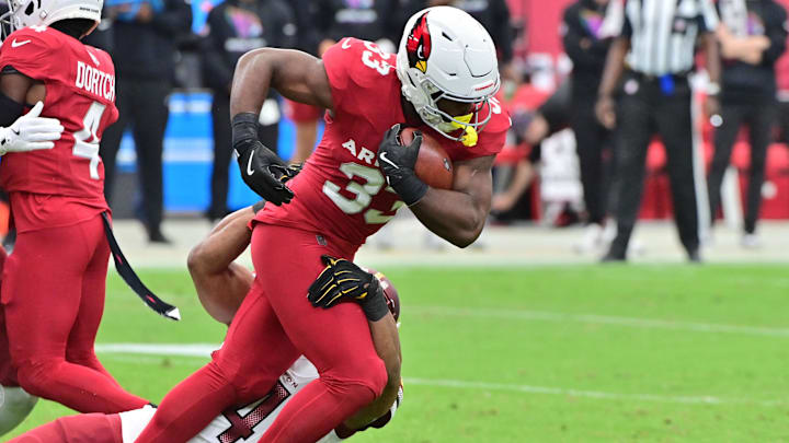 Sep 29, 2024; Glendale, Arizona, USA;  Arizona Cardinals running back Trey Benson (33)runs the ball as Washington Commanders linebacker Bobby Wagner (54) defends in the first half at State Farm Stadium. Mandatory Credit: Matt Kartozian-Imagn Images