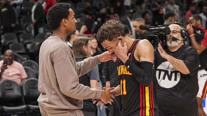 Apr 18, 2025; Atlanta, Georgia, USA; Atlanta Hawks guard Trae Young (11) reacts with injured player Kobe Bufkin after being defeated by the Miami Heat in overtime at State Farm Arena. Mandatory Credit: Dale Zanine-Imagn Images