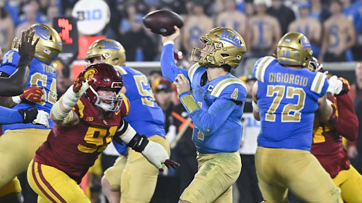 Nov 23, 2024; Pasadena, California, USA; UCLA Bruins quarterback Ethan Garbers (4) throws a pass as USC Trojans defensive tackle Gavin Meyer (91) pressures him during the fourth quarter at Rose Bowl. Mandatory Credit: Robert Hanashiro-Imagn Images