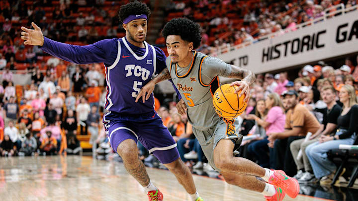 Feb 14, 2026; Stillwater, Oklahoma, USA; Oklahoma State Cowboys guard Vyctorius Miller (5) drives to the basket around TCU Horned Frogs forward Micah Robinson (5) during the first half at Gallagher-Iba Arena. Mandatory Credit: William Purnell-Imagn Images