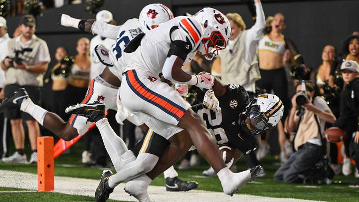 Nov 8, 2025; Nashville, Tennessee, USA;  Auburn Tigers linebacker Bryce Deas (16) and safety Cade Carlson (32) hit Vanderbilt Commodores running back Sedrick Alexander (28) as he crosses the goal line during the second half at FirstBank Stadium. Mandatory Credit: Steve Roberts-Imagn Images