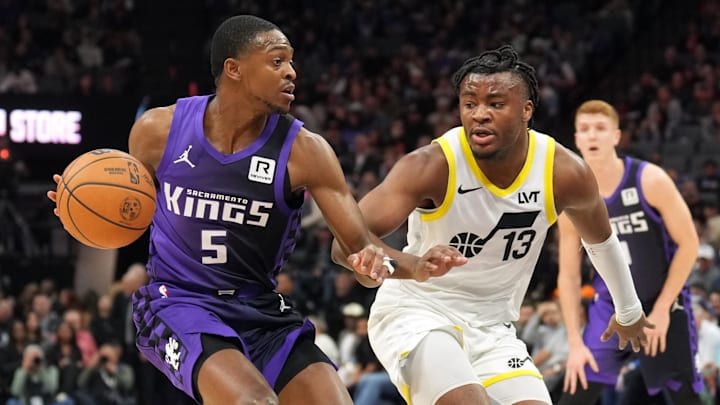 Dec 8, 2024; Sacramento, California, USA; Sacramento Kings guard De'Aaron Fox (5) dribbles against Utah Jazz guard Isaiah Collier (13) during the first quarter at Golden 1 Center. Mandatory Credit: Darren Yamashita-Imagn Images
