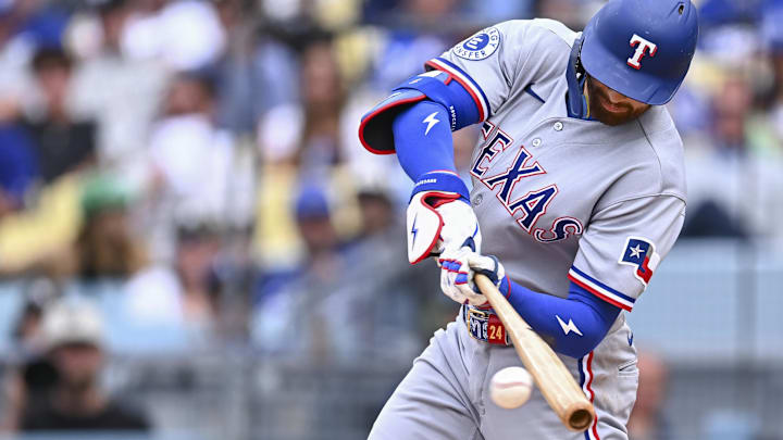 Texas Rangers right fielder Brandon Nimmo hits a baseball with his bat.