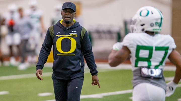 Oregon co-offensive coordinator and wide receivers coach Junior Adams leads a drill during practice at the Moshofsky Center in Eugene.