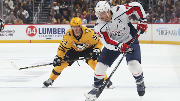 Nov 6, 2025; Pittsburgh, Pennsylvania, USA;  Washington Capitals defenseman John Carlson (74) moves the puck ahead of Pittsburgh Penguins right wing Philip Tomasino (53) during the second period at PPG Paints Arena. Mandatory Credit: Charles LeClaire-Imagn Images
