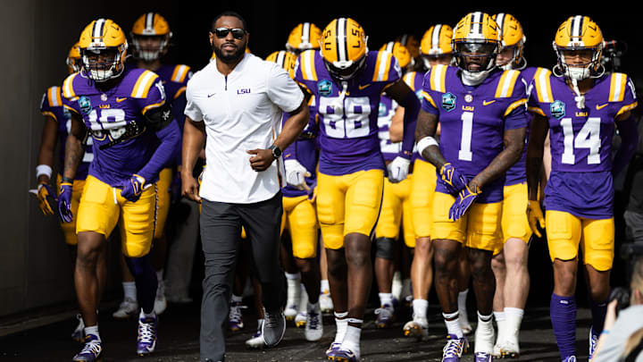 Jan 1, 2024; Tampa, FL, USA; LSU Tigers wide receivers coach Cortez Hankton, tight end Ka'Morreun Pimpton (88), and wide receiver Aaron Anderson (1) run onto the field before the game against the Wisconsin Badgers at Raymond James Stadium. Mandatory Credit: Matt Pendleton-USA TODAY Sports