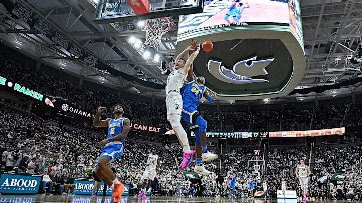 Feb 17, 2026; East Lansing, Michigan, USA; Michigan State Spartans center Carson Cooper (15) draws a flagrant foul call against UCLA Bruins center Steven Jamerson II (24) during the second half at Jack Breslin Student Events Center. Mandatory Credit: Dale Young-Imagn Images