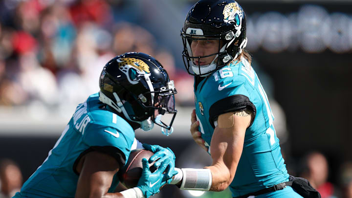 Dec 1, 2024; Jacksonville, Florida, USA; Jacksonville Jaguars quarterback Trevor Lawrence (16) hands off to running back Travis Etienne Jr. (1) against the Houston Texans in the first quarter at EverBank Stadium. Mandatory Credit: Nathan Ray Seebeck-Imagn Images