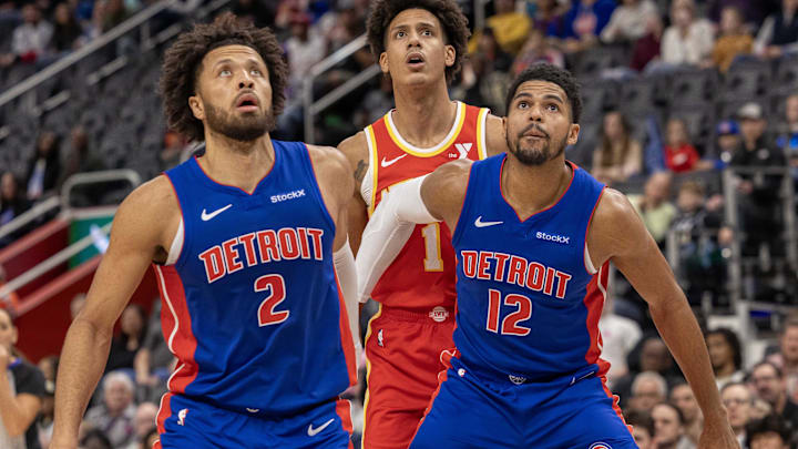 Nov 8, 2024; Detroit, Michigan, USA; Detroit Pistons guard Cade Cunningham (2) and forward Tobias Harris (12) block out Atlanta Hawks forward Jalen Johnson (1) during the first half at Little Caesars Arena. Mandatory Credit: David Reginek-Imagn Images