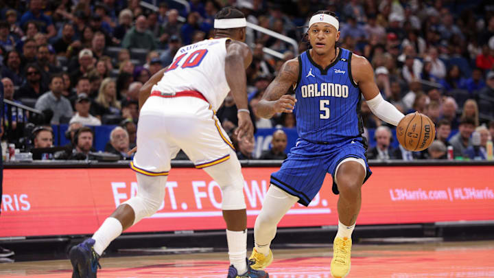 Orlando Magic forward Paolo Banchero (5) is guarded by Golden State Warriors forward Jimmy Butler III (10) in the first quarter at Kia Center.