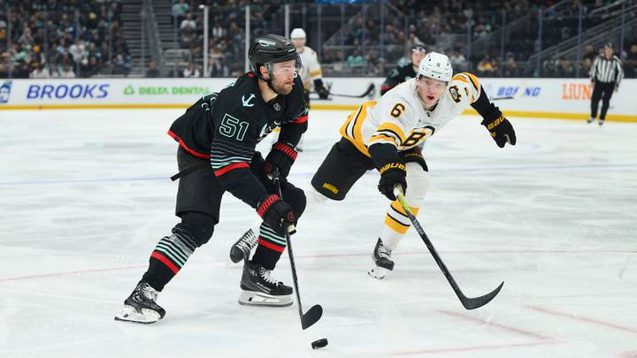 Jan 6, 2026; Seattle, Washington, USA; Seattle Kraken center Shane Wright (51) advances the puck while defended by Boston Bruins defenseman Mason Lohrei (6) during the second period at Climate Pledge Arena. Mandatory Credit: Steven Bisig-Imagn Images